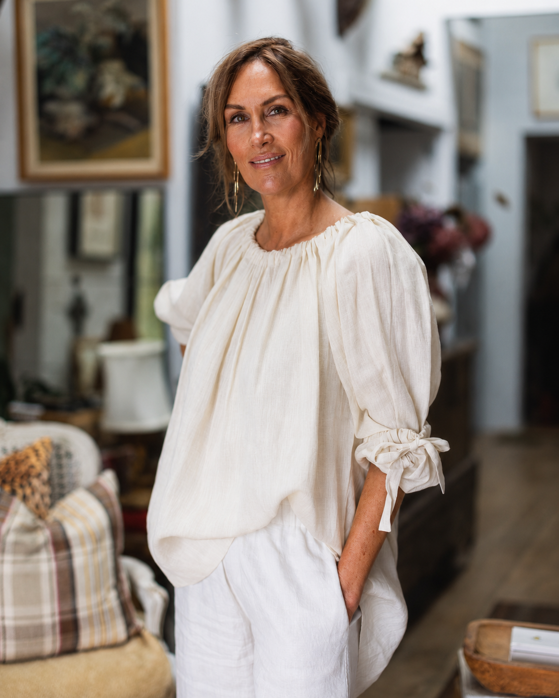 She's More tied, a loose fitting top with drawstring neck and shell button back